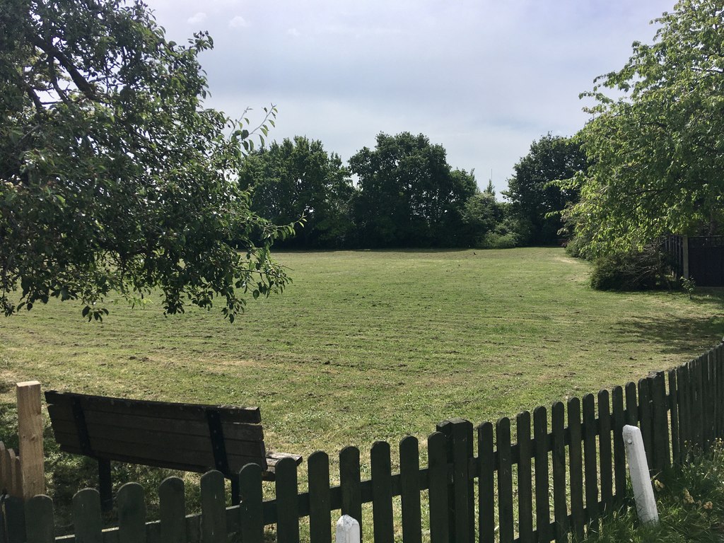 The grassy dog meadow with a bench at Grange Farm, Upper Halliford